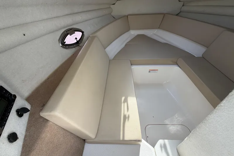 Slide: The Image of Interior cabin of 2014 Chaparral 225 SSi boat with beige seating and porthole. - 32