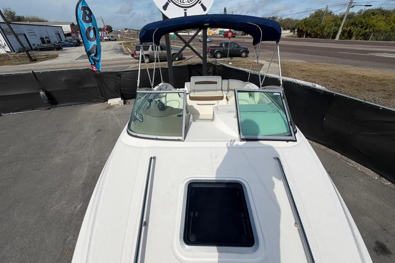 Slide: The Image of 2014 Chaparral 225 SSi boat with blue canopy, parked outdoors. - 40