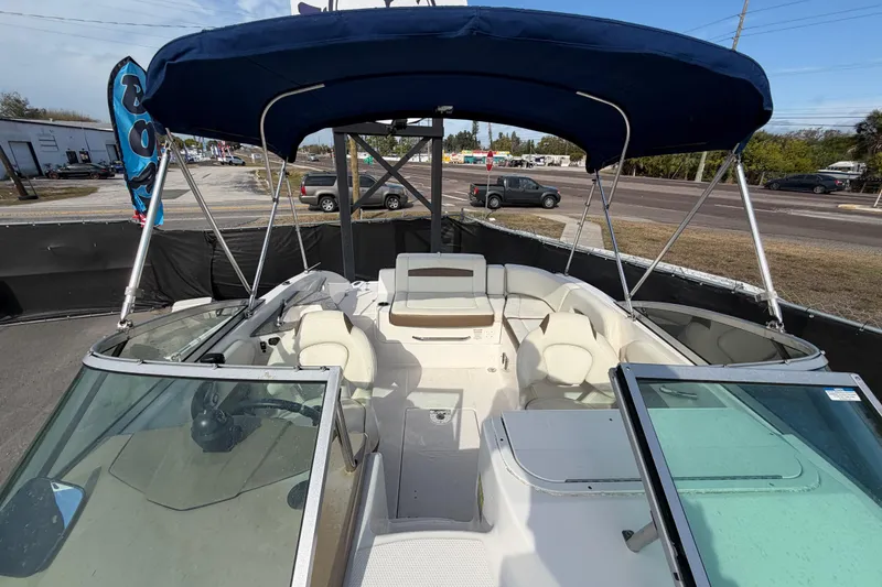 Slide: The Image of 2014 Chaparral 225 SSi boat with blue canopy and spacious seating area. - 42