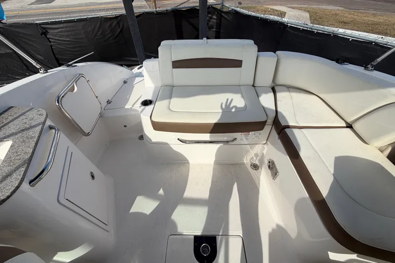 Slide: The Image of 2014 Chaparral 225 SSi boat interior with white seating and storage compartments. - 45