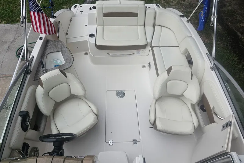 Slide: The Image of 2014 Chaparral 225 SSi boat interior with white seating and American flag. - 6