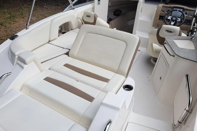 Slide: The Image of 2014 Chaparral 225 SSi boat interior with white and beige seating and steering console. - 7