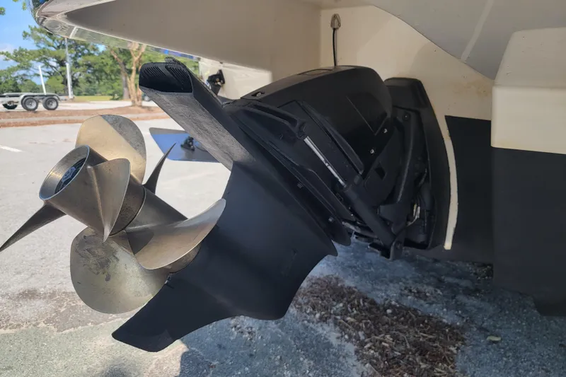 Slide: The Image of 2008 Chaparral Signature 250 boat propeller and outdrive detail in a parking area. - 2