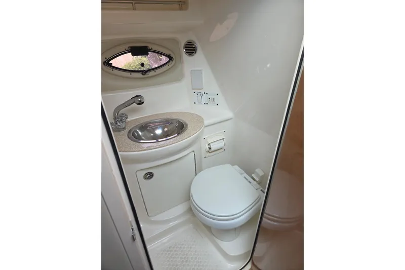 Slide: The Image of 2008 Chaparral Signature 250 boat bathroom with sink, toilet, and porthole window. - 6