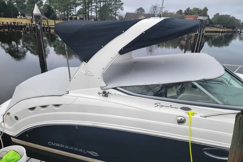 Slide: The Image of 2008 Chaparral Signature 250 boat docked by a calm lake with a covered canopy. - 8