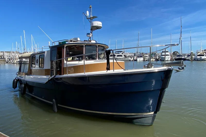 Slide: The Image of 2013 Ranger Tugs R-29 S boat docked in a marina under clear blue skies. - 1