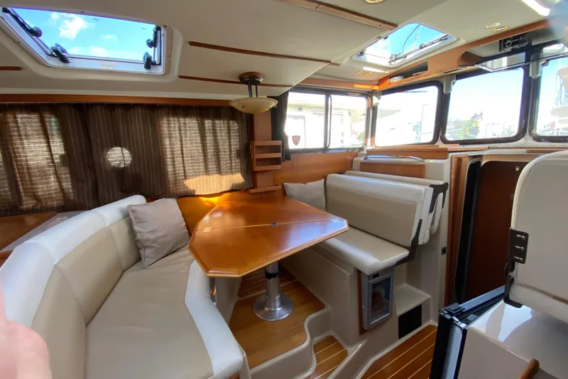 Slide: The Image of Interior of 2013 Ranger Tugs R-29 S with seating and wooden table. - 11