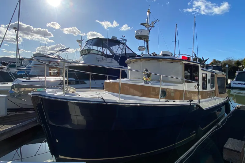 Slide: The Image of 2013 Ranger Tugs R-29 S boat docked under a sunny sky. - 2