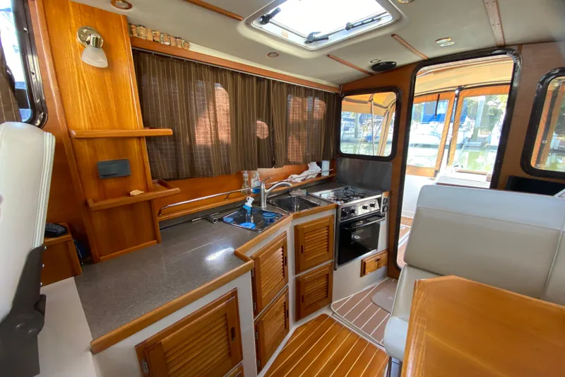 Slide: The Image of Interior of 2013 Ranger Tugs R-29 S boat with kitchen and seating area. - 20