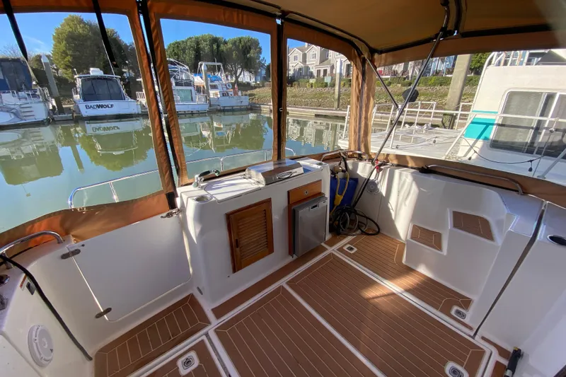 Slide: The Image of 2013 Ranger Tugs R-29 S boat interior with wood flooring and marina view. - 7