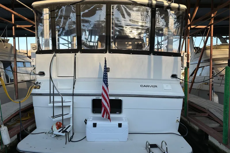 Slide: The Image of 1995 Carver 440 Aft Cabin Motor Yacht docked with American flag displayed. - 18
