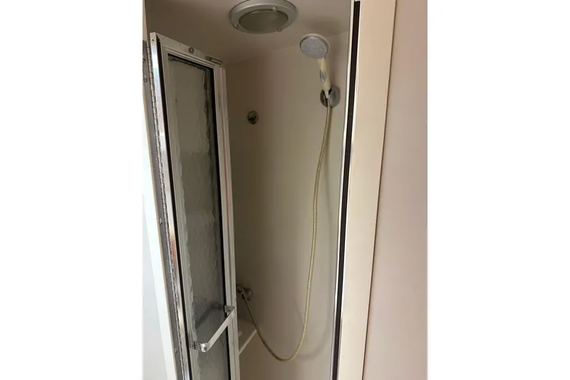 Slide: The Image of Shower area in 1995 Carver 440 Aft Cabin Motor Yacht with glass door and handheld showerhead. - 24