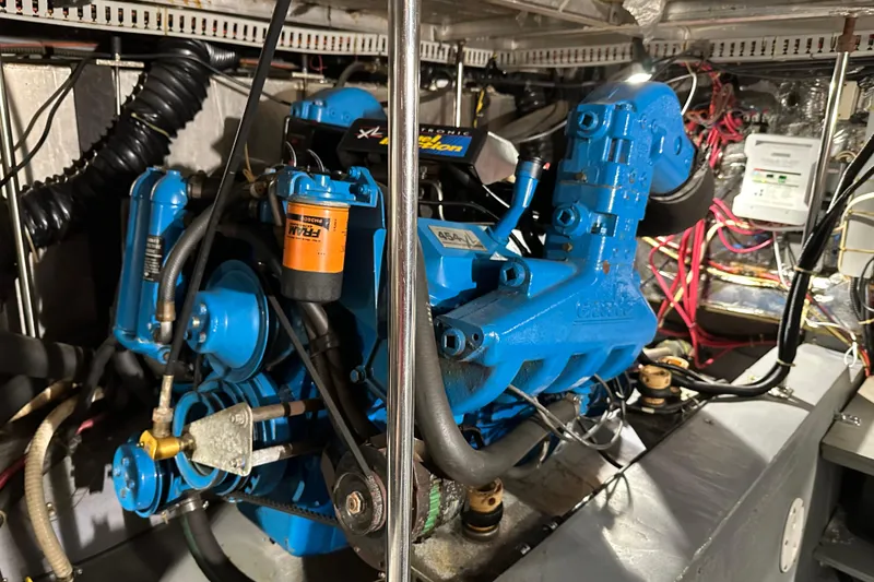 Slide: The Image of Engine room of 1995 Carver 440 Aft Cabin Motor Yacht, featuring a blue marine engine. - 32