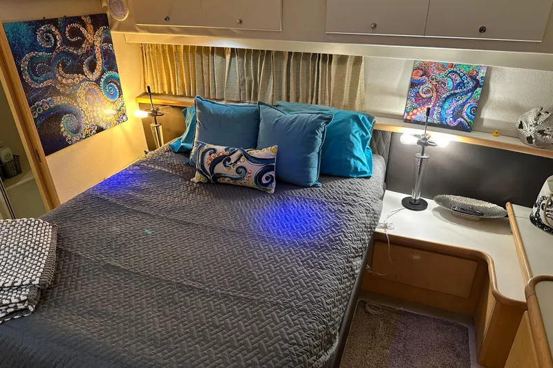 Slide: The Image of Luxurious 1995 Carver 440 Aft Cabin Motor Yacht bedroom with vibrant decor and cozy bedding. - 50