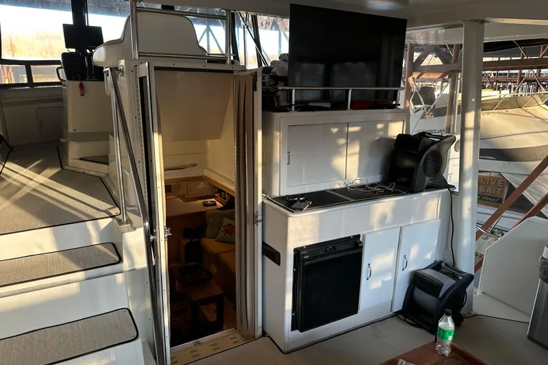 Slide: The Image of 1995 Carver 440 Aft Cabin Motor Yacht interior with stairs, cabinets, and seating area. - 11