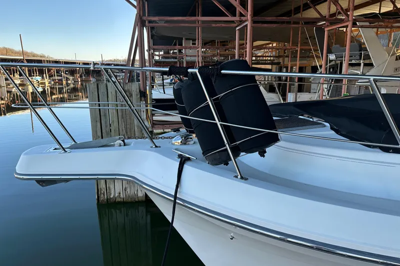 Slide: The Image of 1995 Carver 440 Aft Cabin Motor Yacht docked, featuring sleek bow design and protective fenders. - 23