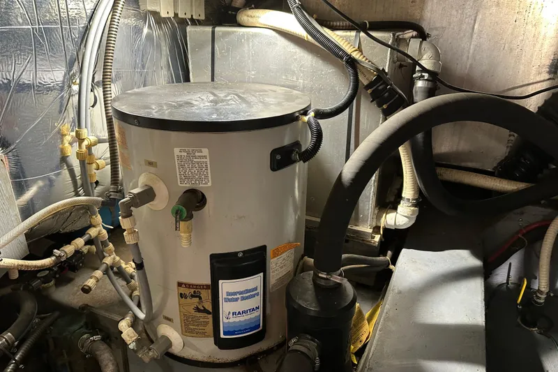 Slide: The Image of Engine room of 1995 Carver 440 Aft Cabin Motor Yacht with water heater and pipes. - 34