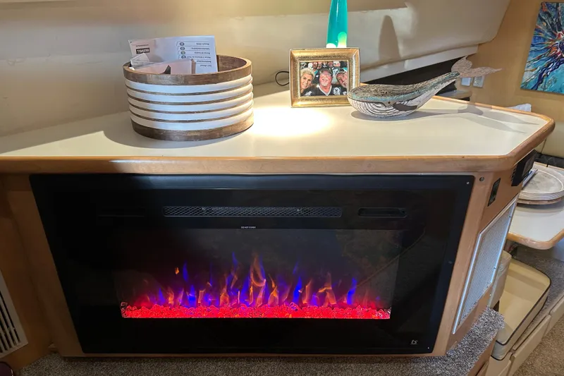 Slide: The Image of Electric fireplace in 1995 Carver 440 Aft Cabin Motor Yacht interior, with decor and photo frame. - 44