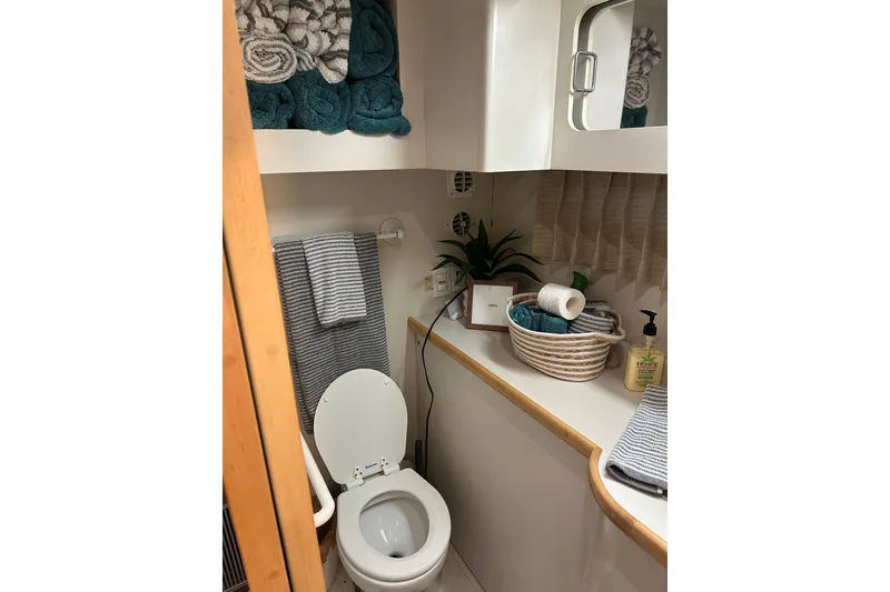 Slide: The Image of Bathroom interior of 1995 Carver 440 Aft Cabin Motor Yacht, featuring towels and toiletries. - 48