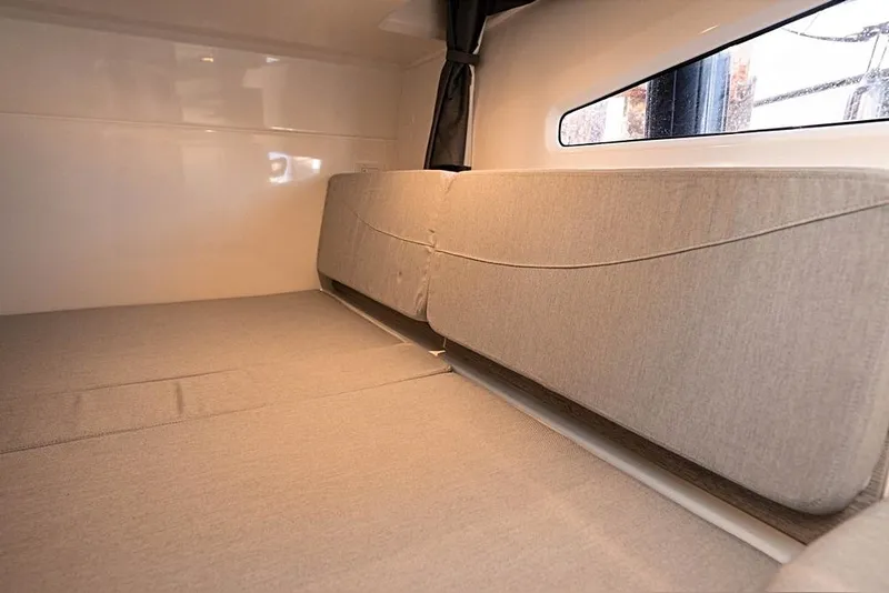 Slide: The Image of 2026 Trophy T29EX Explorer cabin interior with beige cushions and window view. - 18