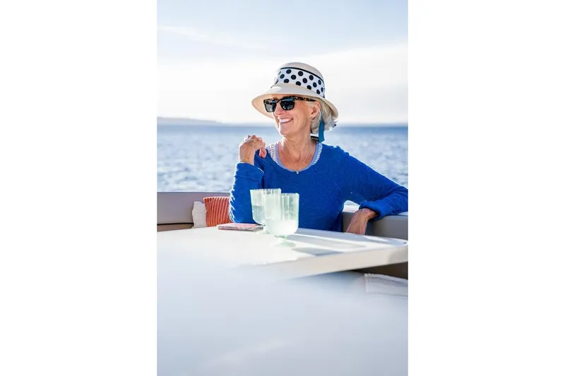 Slide: The Image of Woman relaxing on a 2026 Trophy T29EX Explorer boat, wearing a hat and sunglasses. - 29