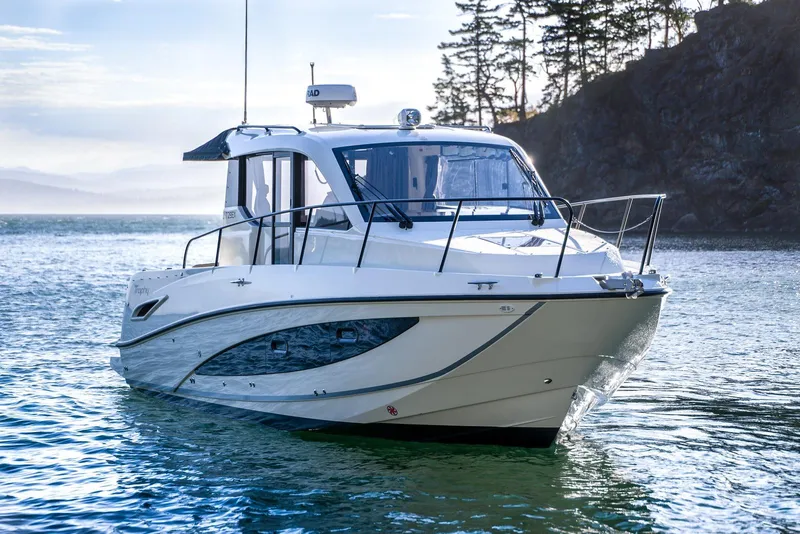 Slide: The Image of 2026 Trophy T29EX Explorer boat on serene water near rocky shoreline. - 3