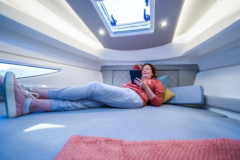 Slide: The Image of Woman relaxing in 2026 Trophy T29EX Explorer cabin, reading on a tablet. - 36