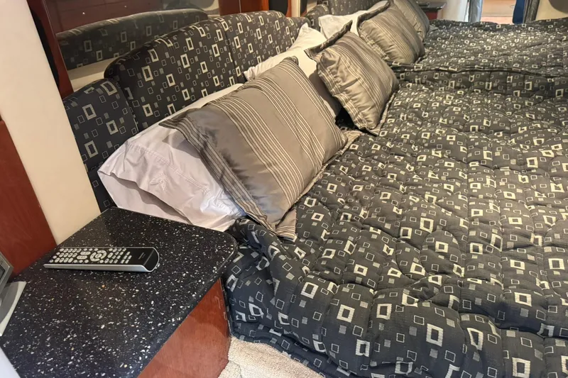 Slide: The Image of Luxurious bed in 2008 Formula 400 Super Sport cabin with patterned bedding and remote control. - 24