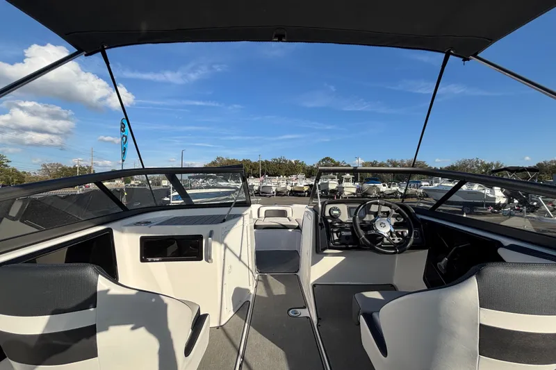 Slide: The Image of 2022 Yamaha Boats SX195 interior with steering wheel and seating, under clear blue sky. - 23