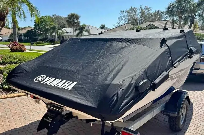 Slide: The Image of 2022 Yamaha SX195 boat covered, parked on a sunny residential driveway. - 3
