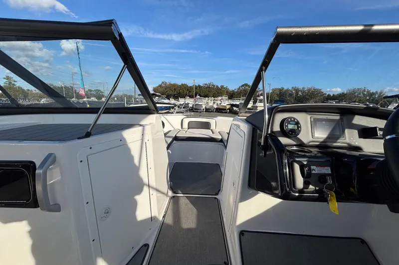 Slide: The Image of 2022 Yamaha Boats SX195 interior with dashboard and seating, under a clear blue sky. - 35