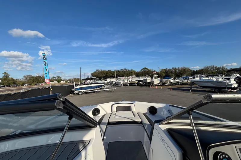 Slide: The Image of 2022 Yamaha Boats SX195 at a boat dealership under a clear blue sky. - 37