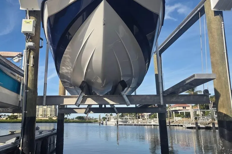 Slide: The Image of 2022 Yamaha Boats SX195 on a lift at a marina, clear sky background. - 4