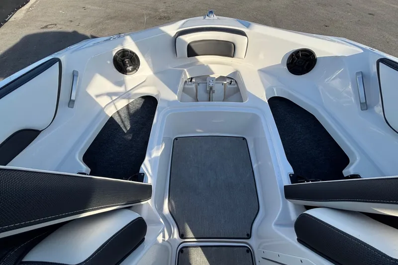Slide: The Image of 2022 Yamaha Boats SX195 bow seating area with speakers and storage compartments. - 43