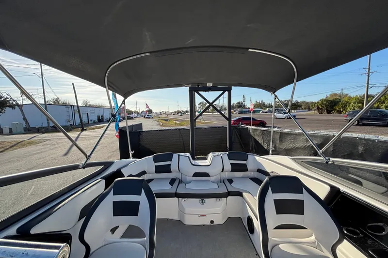 Slide: The Image of 2022 Yamaha Boats SX195 interior with seating and canopy, parked near a road. - 52