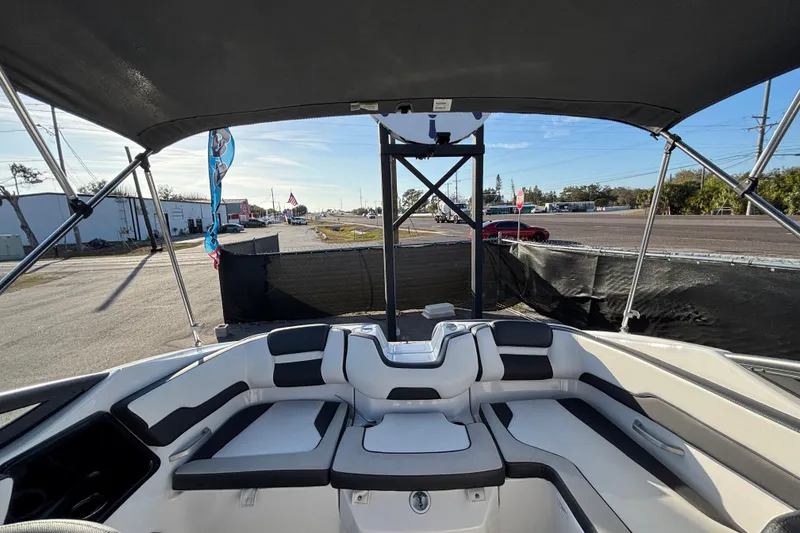 Slide: The Image of 2022 Yamaha Boats SX195 interior with seating, under a canopy, in a parking area. - 54