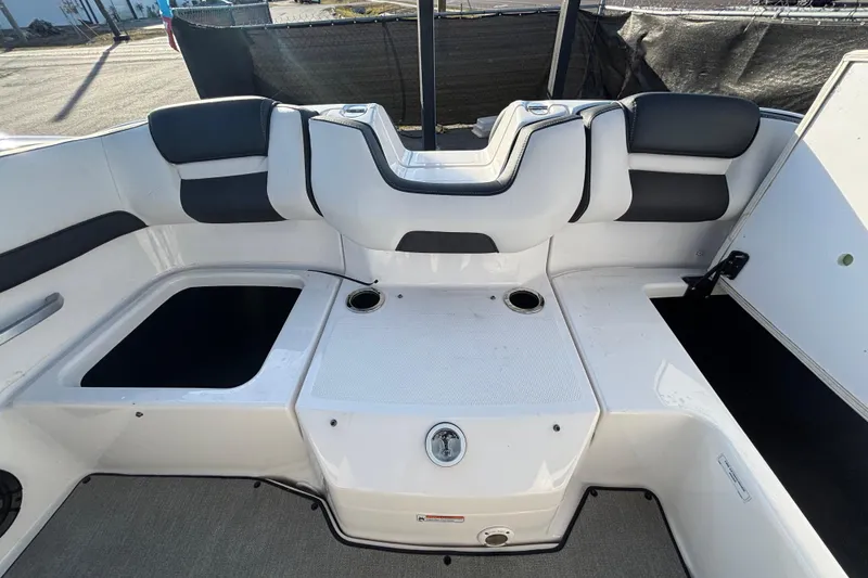 Slide: The Image of 2022 Yamaha Boats SX195 interior seating area with cup holders and storage compartments. - 57