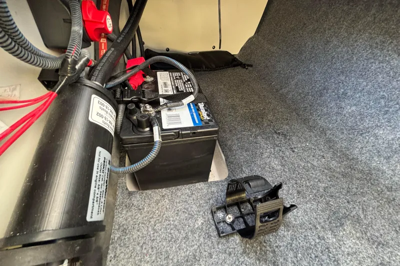 Slide: The Image of 2022 Yamaha Boats SX195 battery compartment with wiring and components. - 58