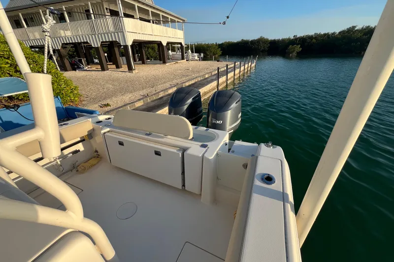 Slide: The Image of 2014 Cobia 296 Center Console boat docked by waterfront house. - 11