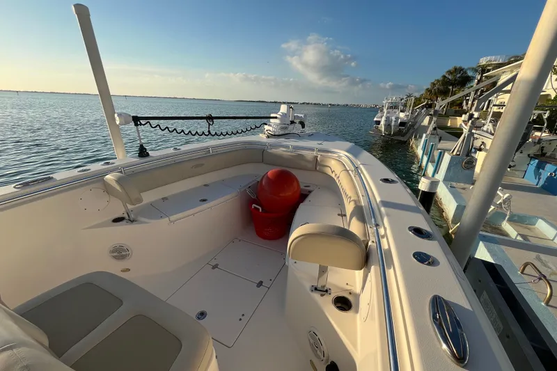 Slide: The Image of 2014 Cobia 296 Center Console boat docked by the water on a sunny day. - 13