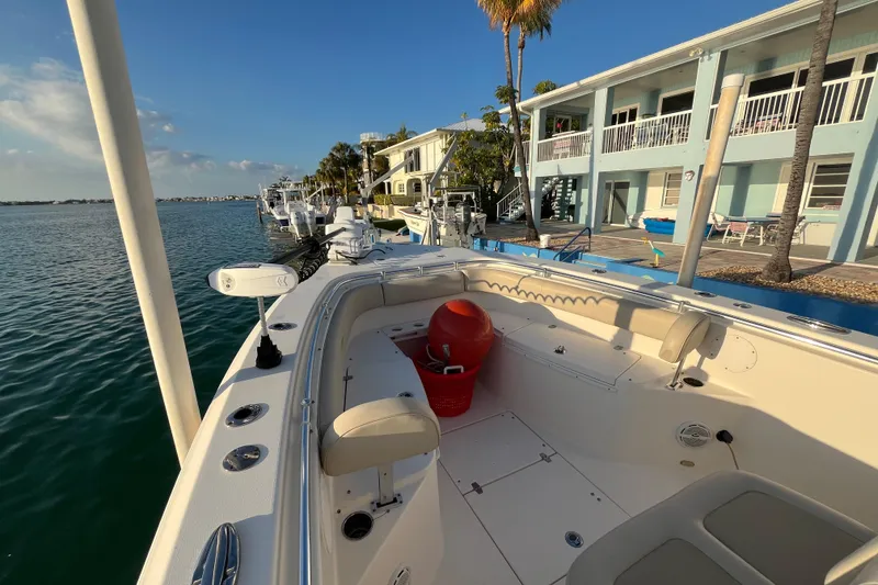 Slide: The Image of 2014 Cobia 296 Center Console boat docked by waterfront homes under clear blue sky. - 14