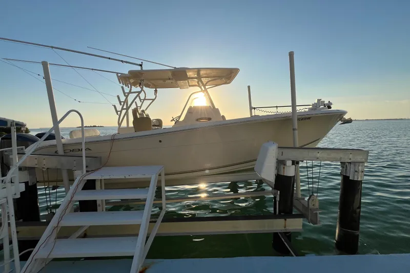 Slide: The Image of 2014 Cobia 296 Center Console boat docked at sunset, calm waters. - 2