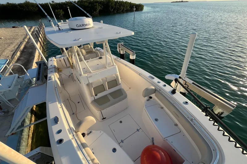 Slide: The Image of 2014 Cobia 296 Center Console boat docked by the water, featuring a Garmin system. - 4