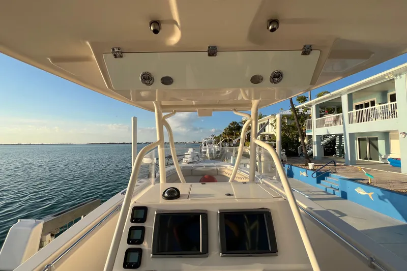 Slide: The Image of 2014 Cobia 296 Center Console boat docked by waterfront property. - 9