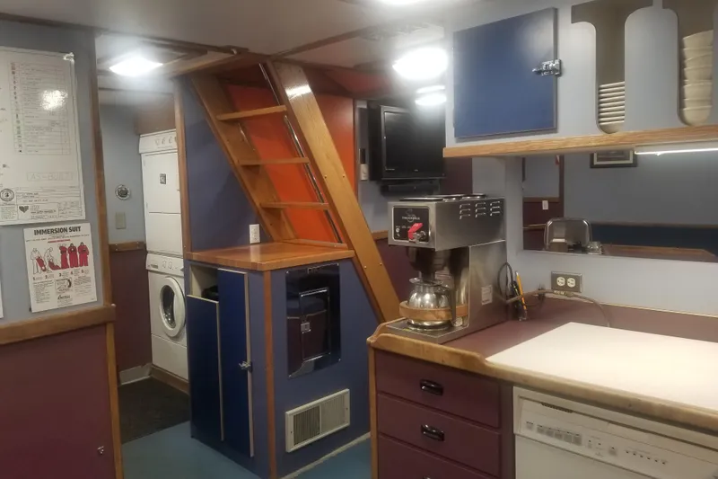 Slide: The Image of 1974 Custom Steel Cannery Tender interior with kitchen, coffee maker, and laundry area. - 7