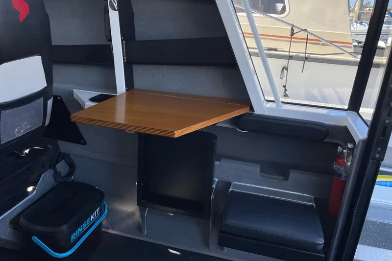 Slide: The Image of 2017 Stabicraft 2500 Ultracab XL interior with helm, steering wheel, and marina view. - 33