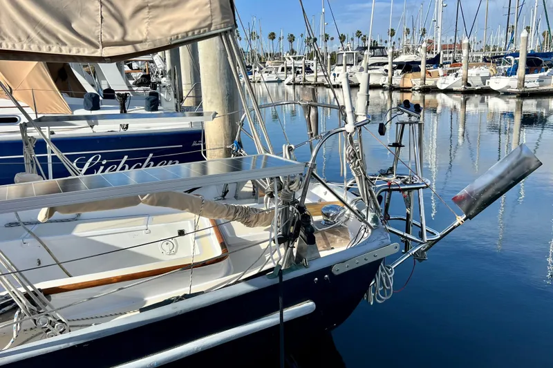 Slide: The Image of Sailboat Cape George 36, 1975 model, docked in a marina with clear reflections. - 11