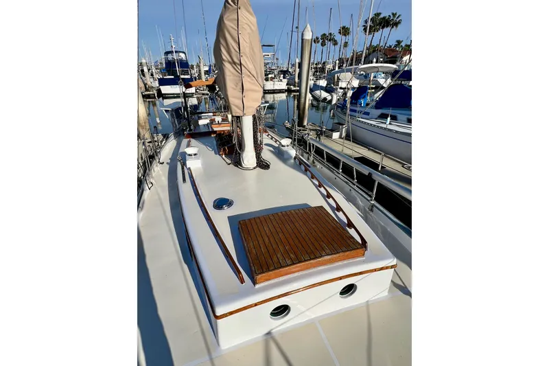 Slide: The Image of 1975 Cape George 36 sailboat deck with wooden accents, docked in a marina. - 24