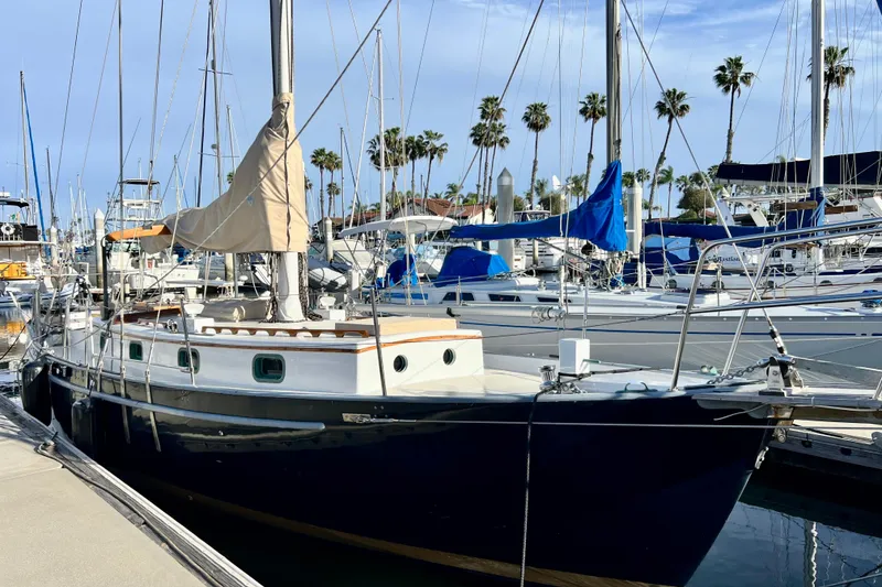 Slide: The Image of 1975 Cape George 36 sailboat docked in marina with palm trees in background. - 3