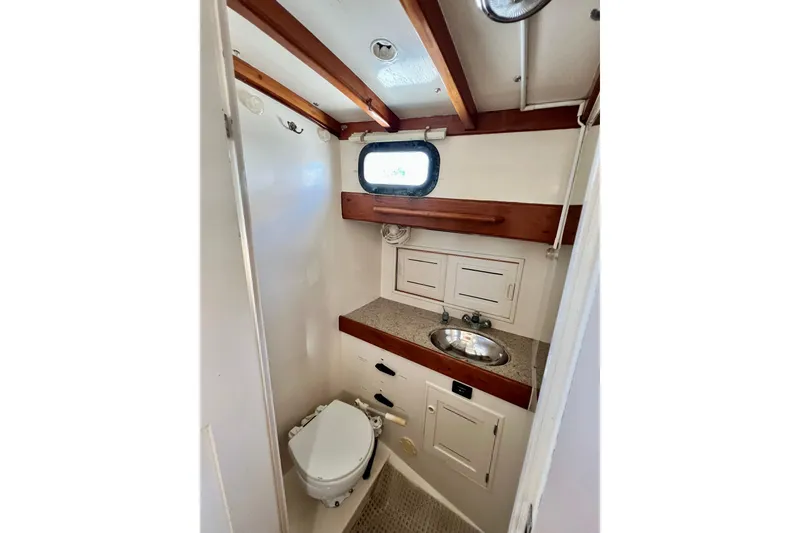 Slide: The Image of 1975 Cape George 36 yacht bathroom with sink, toilet, and wooden accents. - 65